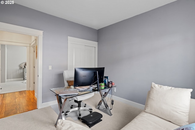 home office with carpet floors, baseboards, and wood finished floors