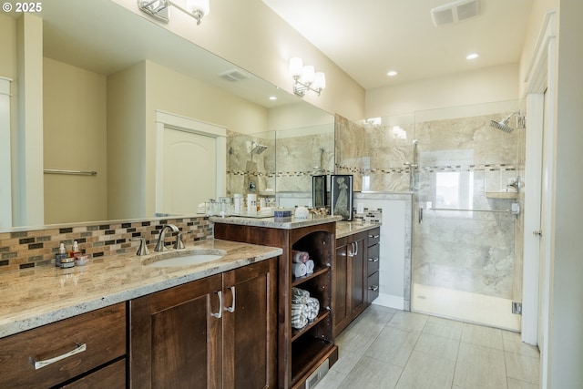 bathroom with a shower stall, visible vents, backsplash, and vanity