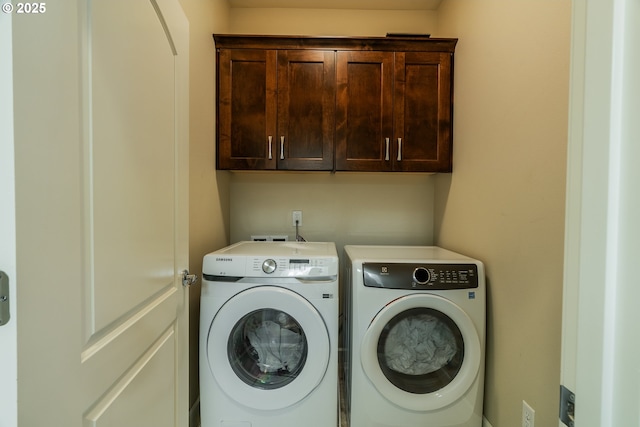 washroom with cabinet space and washing machine and dryer