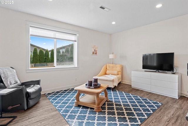 living room featuring recessed lighting, wood finished floors, visible vents, and baseboards