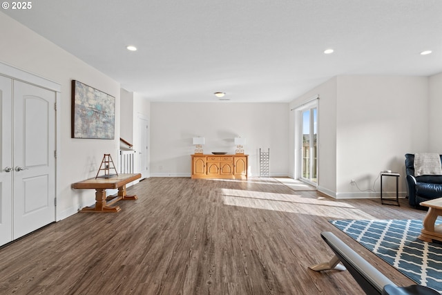 living area with recessed lighting, stairway, baseboards, and wood finished floors