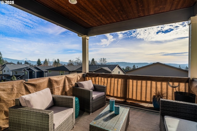 wooden deck with an outdoor living space, a residential view, and a mountain view