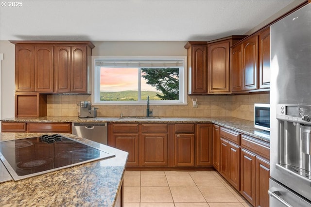 9595 SW Old Highway 47, Gaston, OR 97119 - kitchen with appliances with stainless steel finishes, a sink, brown cabinetry, and light stone countertops