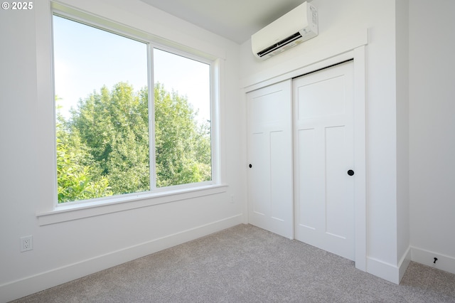 319 N Holland St, Portland, OR 97217 - unfurnished bedroom featuring an AC wall unit, carpet flooring, a closet, and baseboards
