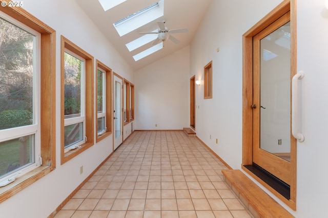 unfurnished sunroom with lofted ceiling with skylight and ceiling fan