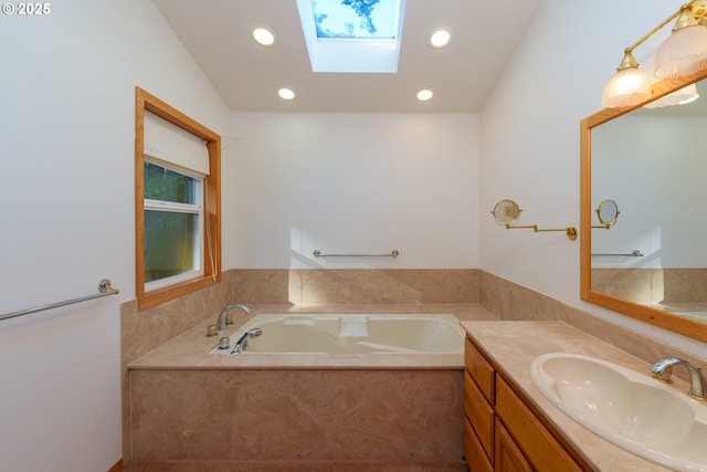 bathroom featuring vanity, a bath, and a skylight