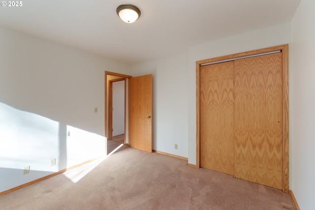 unfurnished bedroom featuring a closet and light carpet