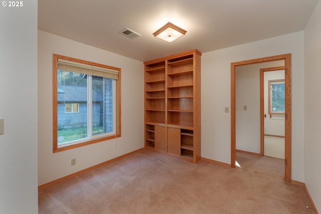 unfurnished bedroom with light colored carpet and a closet