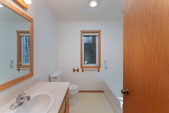 bathroom with vanity, a washtub, and toilet