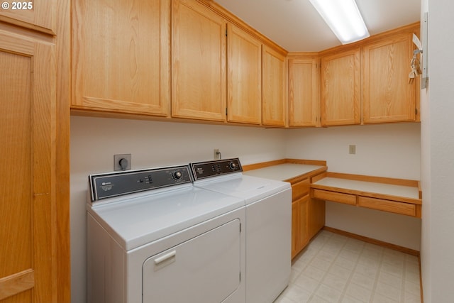 clothes washing area with separate washer and dryer and cabinets