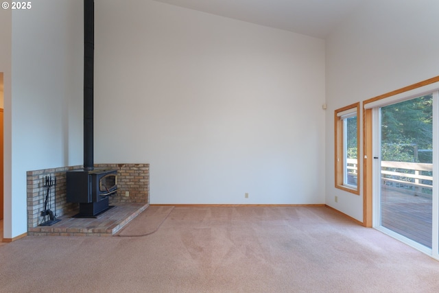 unfurnished living room with a wood stove and light carpet