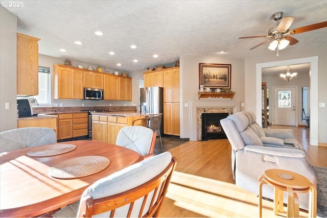 kitchen with hardwood / wood-style flooring, stainless steel appliances, an inviting chandelier, and a textured ceiling