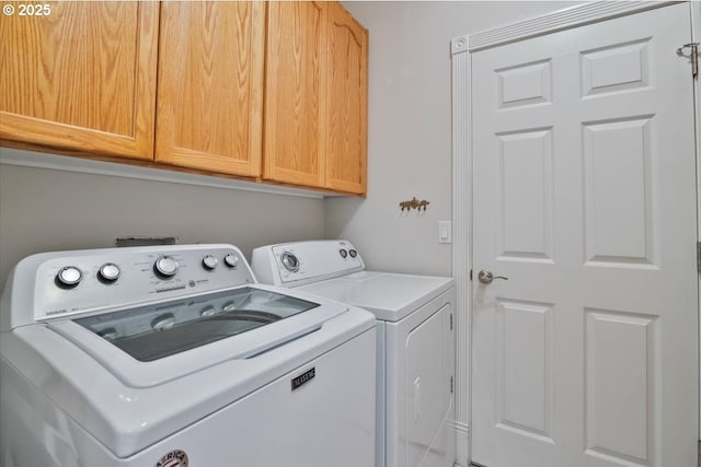 washroom featuring cabinets and washing machine and dryer