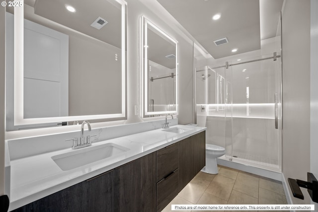 bathroom featuring toilet, vanity, tile patterned flooring, and a shower with shower door