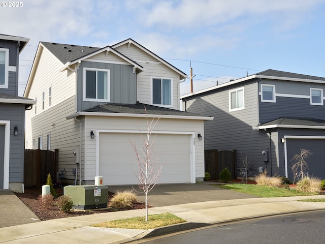 traditional home featuring board and batten siding, fence, driveway, and an attached garage