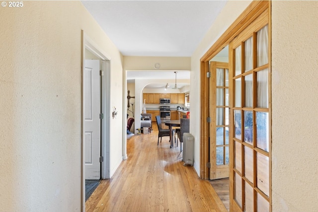 31958 J P W Rd, Scappoose, OR 97056 - hall featuring light wood-style flooring, arched walkways, and a textured wall