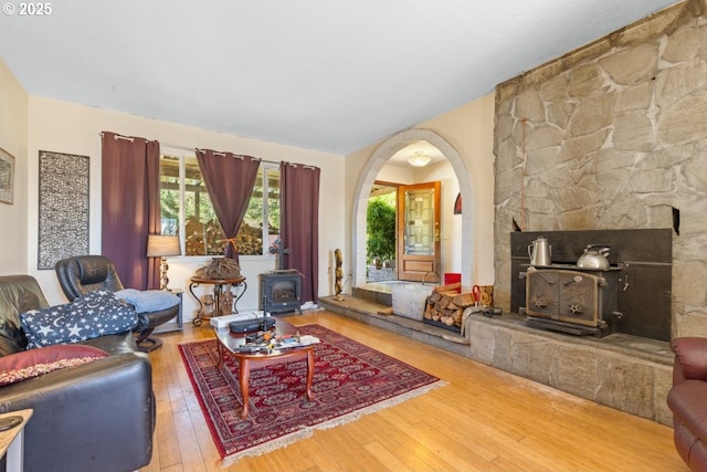 31958 J P W Rd, Scappoose, OR 97056 - living room featuring a wood stove, arched walkways, hardwood / wood-style flooring, and lofted ceiling