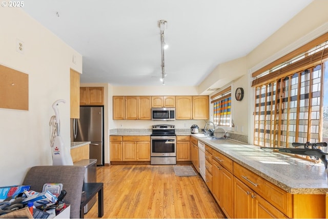31958 J P W Rd, Scappoose, OR 97056 - kitchen with stainless steel appliances, light wood-style flooring, light stone countertops, rail lighting, and a sink