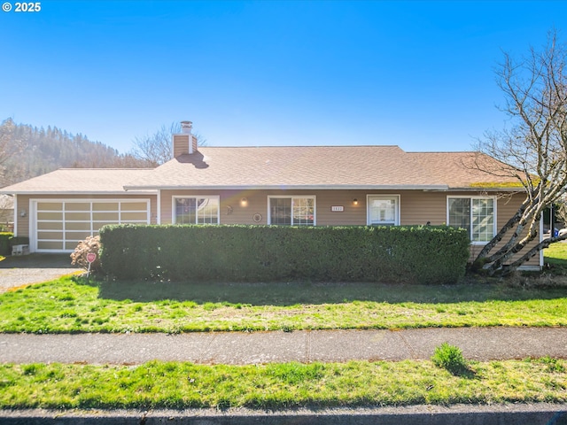 ranch-style home with a garage, driveway, and a chimney