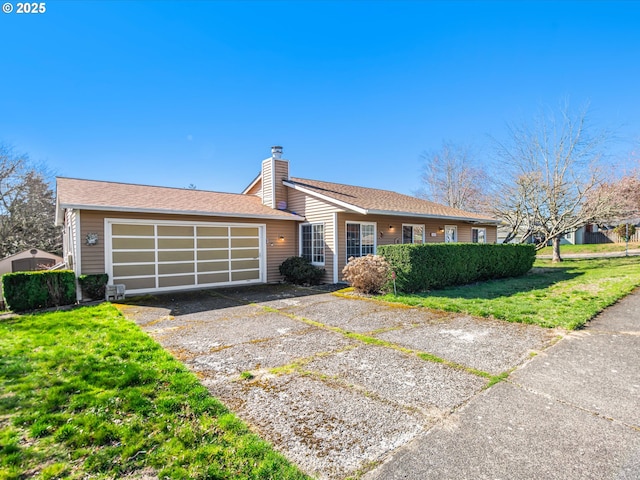 view of front of house featuring an attached garage, driveway, a chimney, and a front yard