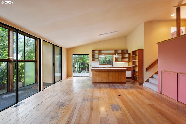 6438 SW Barnes Rd, Portland, OR 97221 - kitchen featuring open shelves, light wood-style flooring, lofted ceiling, a center island, and decorative light fixtures