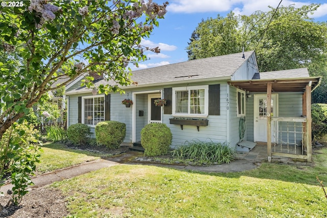 bungalow-style house with roof with shingles and a front yard