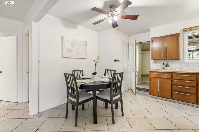dining room with light tile patterned floors, baseboards, and a ceiling fan