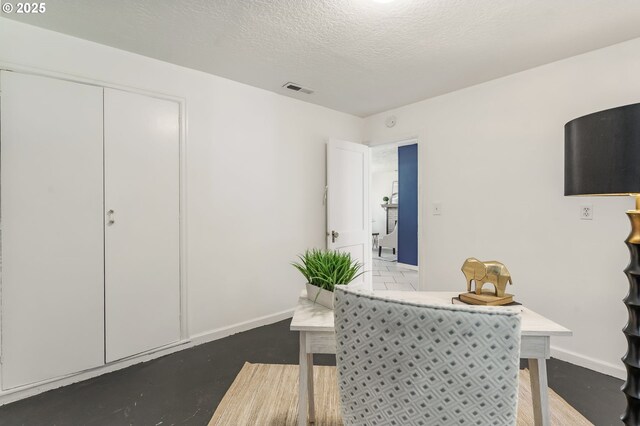 dining area with baseboards, a textured ceiling, and visible vents