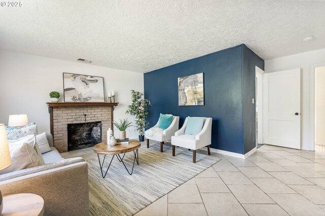 living area with a textured ceiling, visible vents, a fireplace, light tile patterned floors, and baseboards