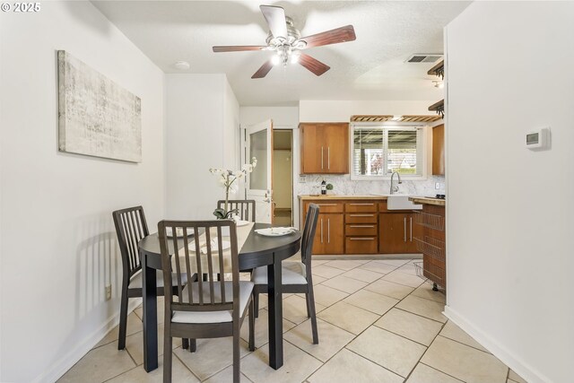 dining room with baseboards, ceiling fan, light tile patterned flooring, and visible vents
