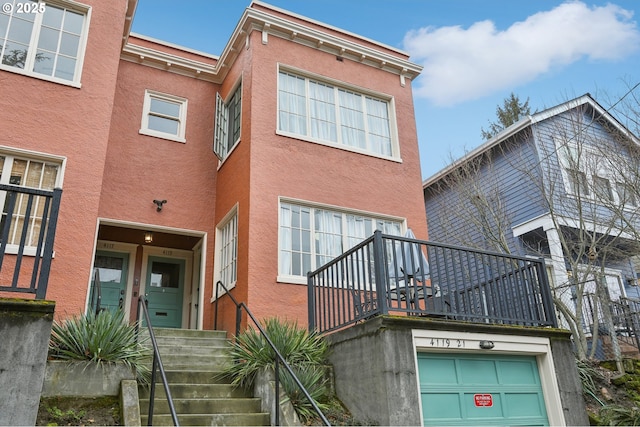 4121 N Albina Ave, Portland, OR 97217 - view of front of home with stairway, a garage, and stucco siding