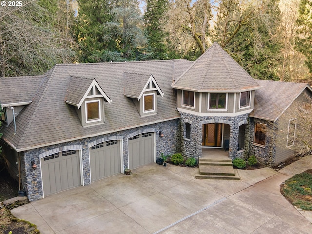 view of front of house with concrete driveway, stone siding, and roof with shingles