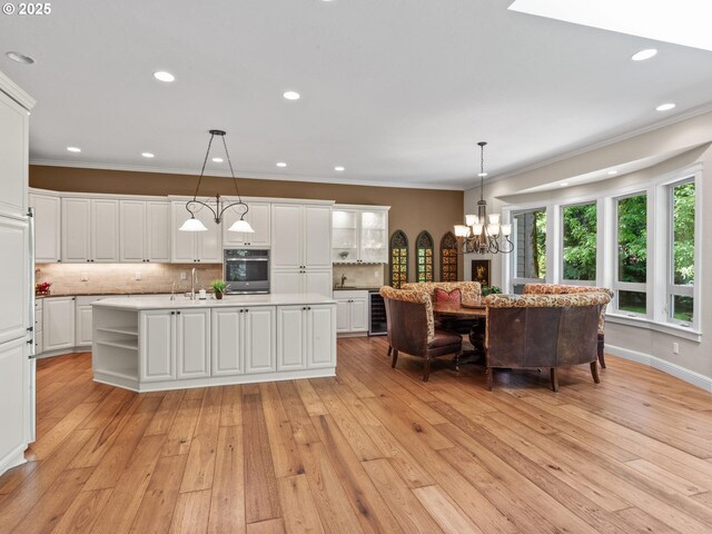4207 SE Aldercrest Rd, Milwaukie, OR 97222 - kitchen featuring a kitchen island with sink, a chandelier, beverage cooler, light countertops, and tasteful backsplash