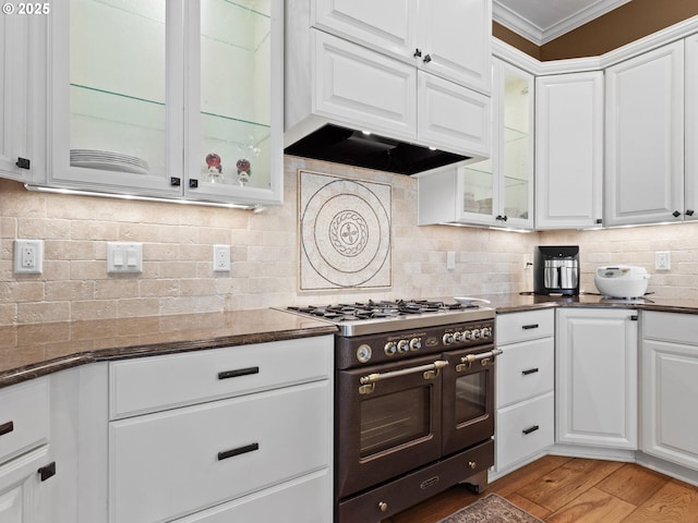 kitchen featuring backsplash, white cabinetry, and range with two ovens