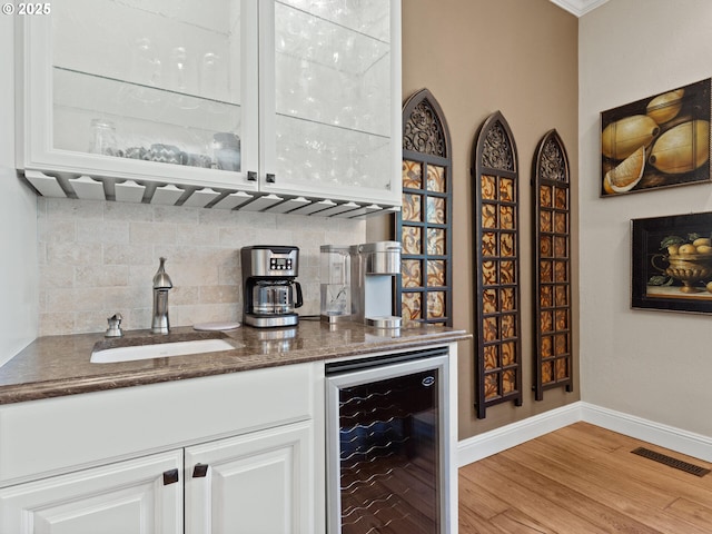 bar with visible vents, a sink, backsplash, wine cooler, and a dry bar