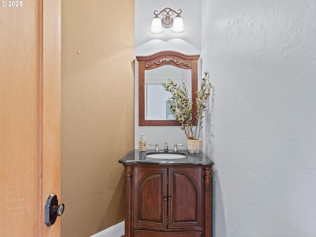 bathroom with vanity and a textured wall