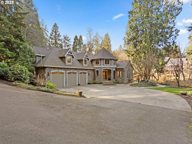 shingle-style home featuring stone siding, concrete driveway, and a garage