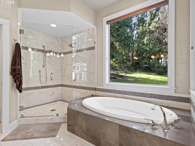 bathroom featuring a wealth of natural light, a garden tub, marble finish floor, and a shower stall