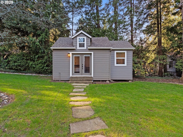 view of front of home with french doors, roof with shingles, and a front lawn