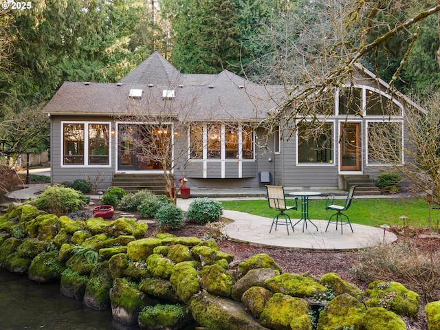 back of property featuring entry steps, a patio area, and roof with shingles