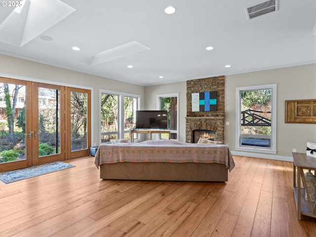 bedroom with a skylight, multiple windows, visible vents, and light wood finished floors