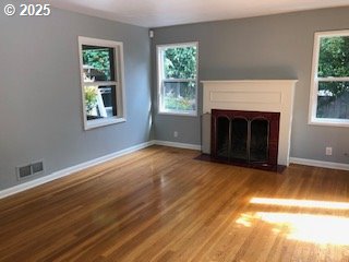 7922 SW Capitol Hill Rd, Portland, OR 97219 - unfurnished living room featuring wood finished floors, baseboards, and a fireplace with flush hearth