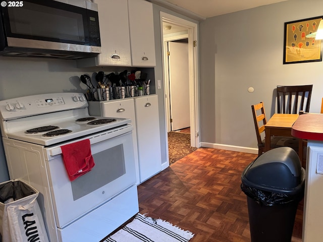 7922 SW Capitol Hill Rd, Portland, OR 97219 - kitchen with stainless steel microwave, electric stove, white cabinets, and baseboards