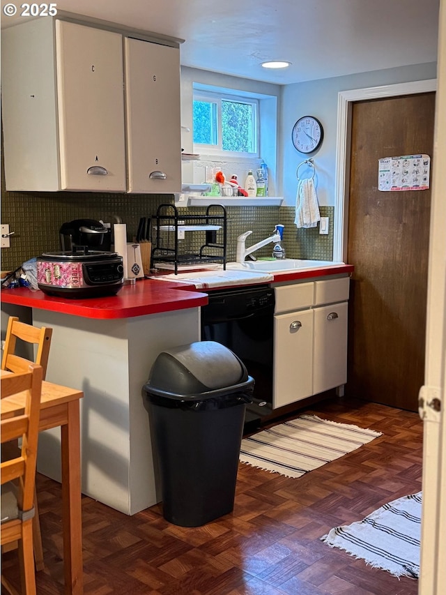 7922 SW Capitol Hill Rd, Portland, OR 97219 - kitchen with decorative backsplash, white cabinetry, black dishwasher, and a sink