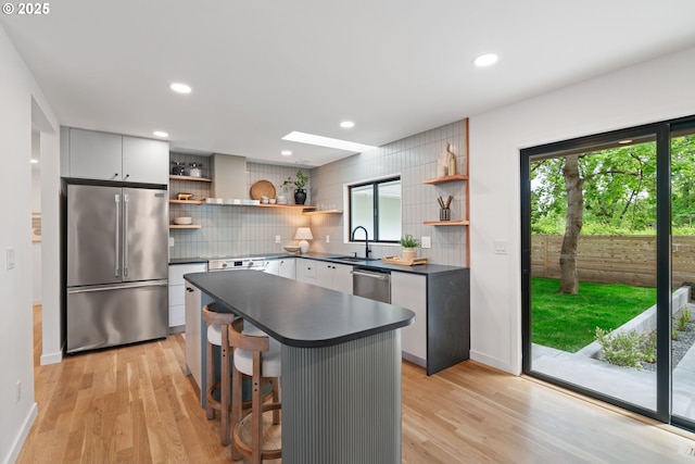 kitchen with appliances with stainless steel finishes, open shelves, dark countertops, backsplash, and recessed lighting