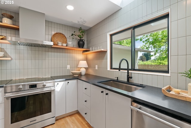 kitchen with open shelves, stainless steel appliances, a sink, extractor fan, and recessed lighting