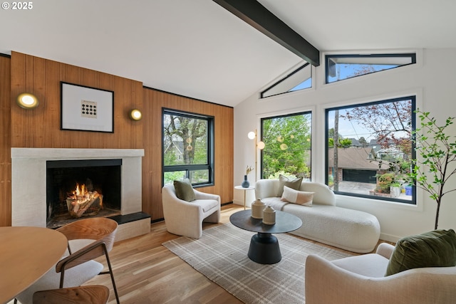 sitting room with wood finished floors, wooden walls, and a premium fireplace
