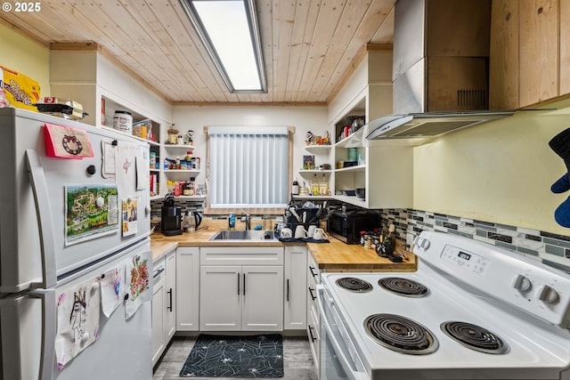 kitchen featuring butcher block counters, white electric stove, wall chimney exhaust hood, and refrigerator