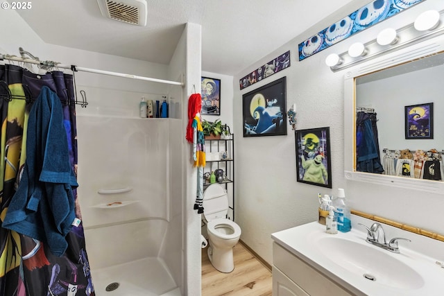 bathroom featuring vanity, toilet, curtained shower, and hardwood / wood-style floors