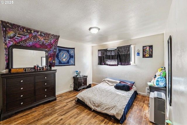 bedroom featuring hardwood / wood-style flooring and a textured ceiling